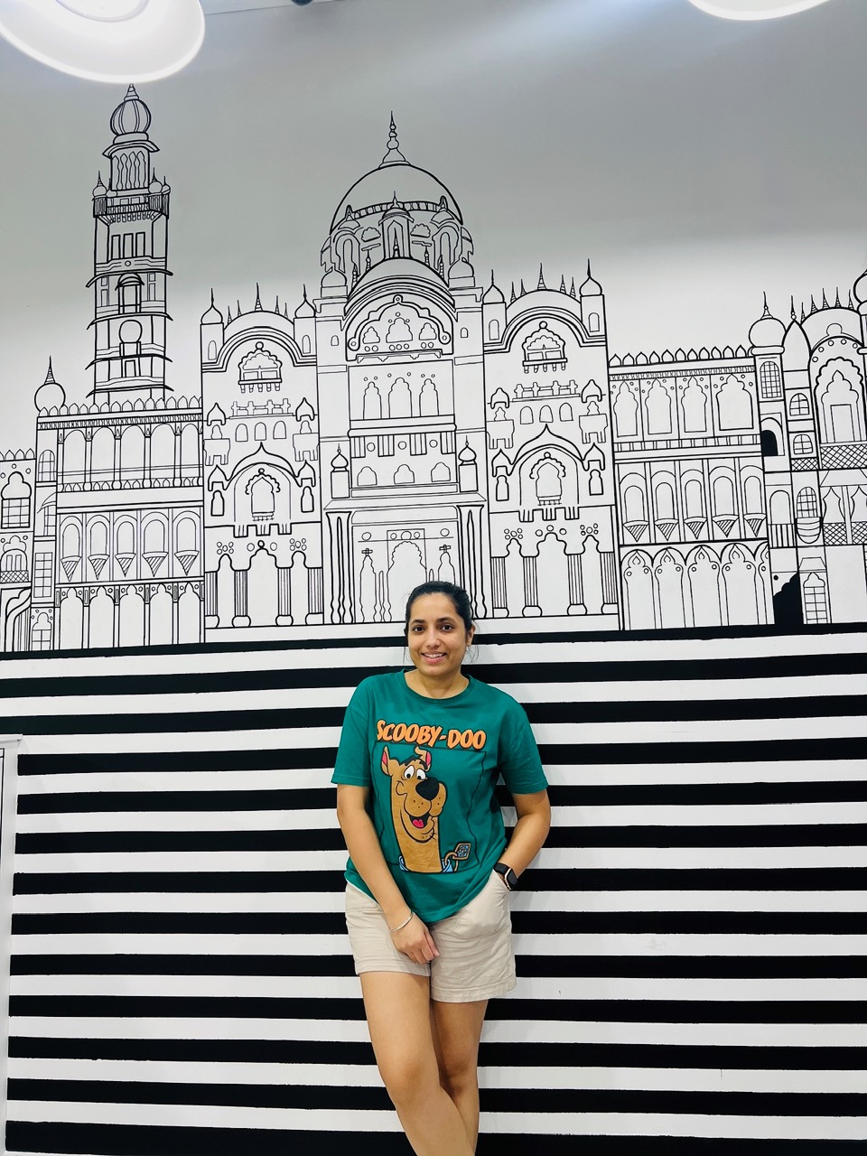 Hirwa in front of one of her hand-drawn 2D murals